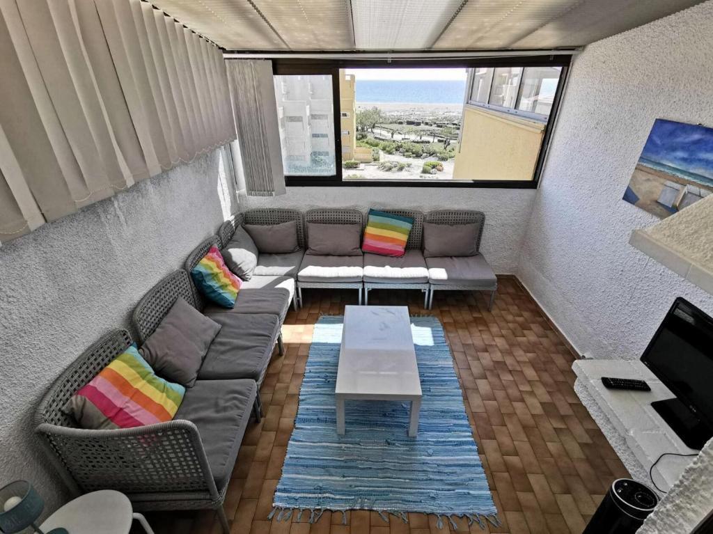 un salon avec un canapé et une table dans l'établissement Résidence LES NEFS DES SABLES - 3 Pièces pour 5 Personnes 24, à Port-Leucate