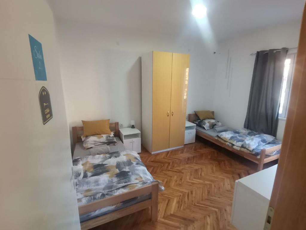 2 Betten in einem Zimmer mit Holzböden in der Unterkunft V&U Sobe in Brzi Brod