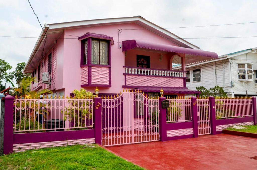 una casa rosa con una valla púrpura en Casa Rosa en Georgetown