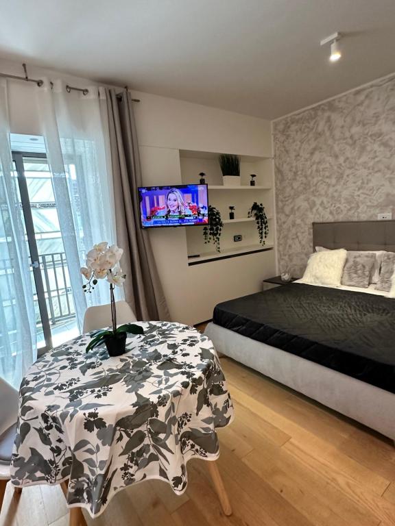 um quarto com uma cama, uma mesa e uma televisão em Palazzo Metropolis em Bari