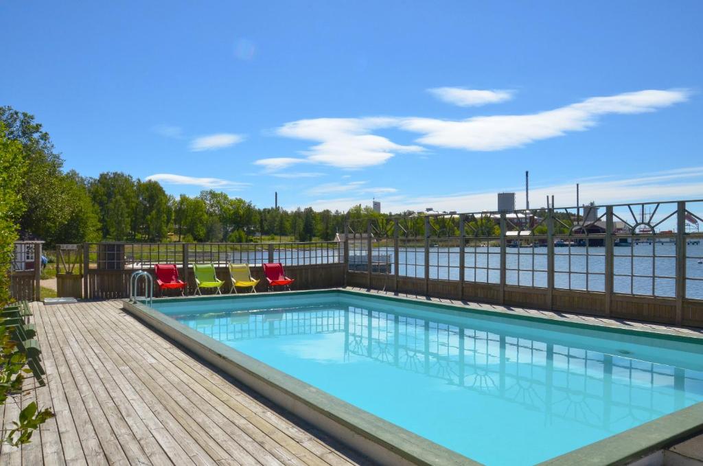 a swimming pool with a view of the water at Strandbergs Stugor in Mariehamn