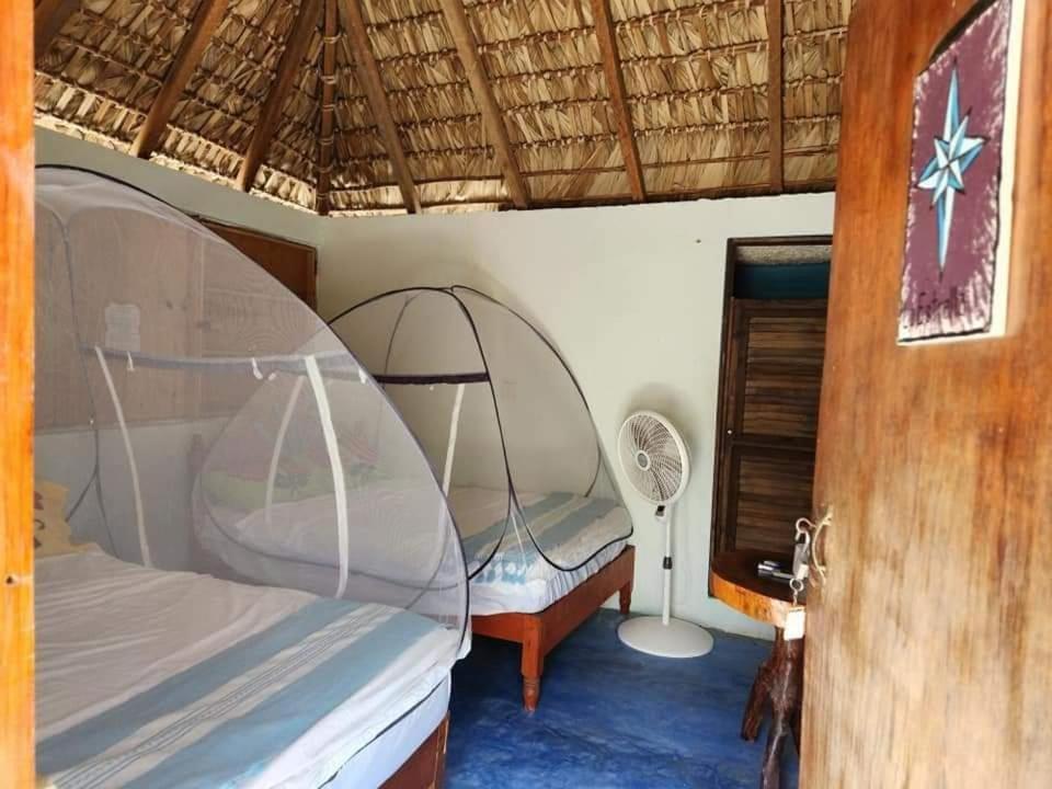 1 dormitorio con cama con dosel y ventilador en Cabañas Paraiso Chacahua, en Chamuscadero