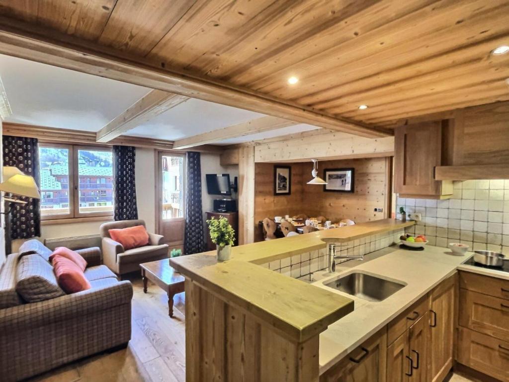 une cuisine avec un évier et un salon dans l'établissement Résidence Aquila - Superbe appartement 3 pièces cabine pour 8 personnes situé à Val d’Isère, skis aux pieds et à 500m du centre du village, navette MAE-2544, à Val dʼIsère
