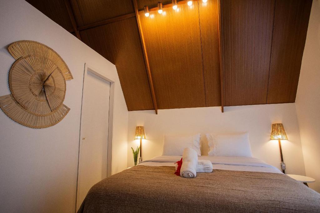 um quarto com uma cama e uma ventoinha na parede em Cabana Mulungu - Viagem Inspirada em Fernando de Noronha