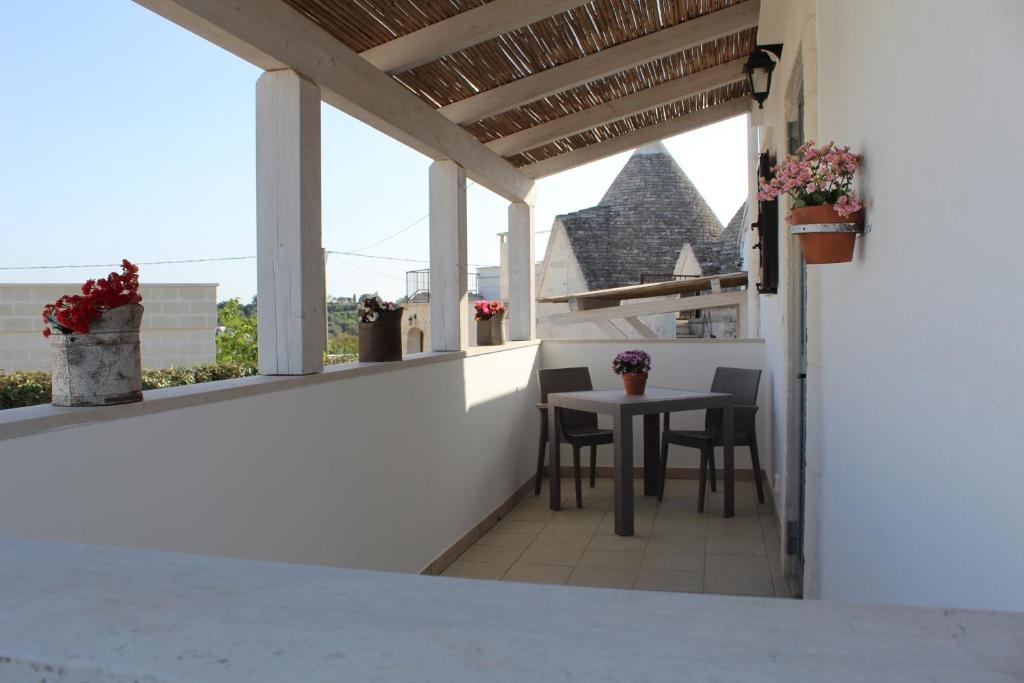 a patio with a table and chairs on a balcony at Trulli Nonna Grazia -miramonti in Cisternino