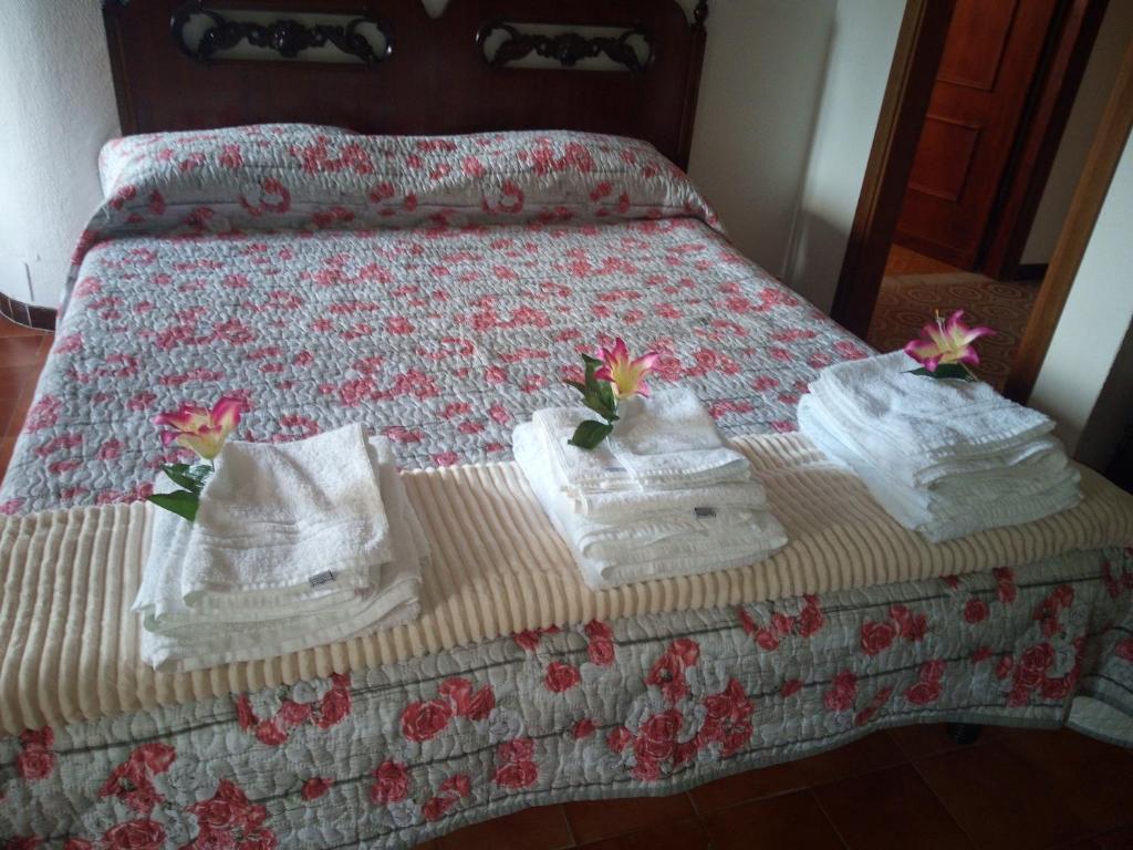 a bed with towels and flowers on top of it at Casa Martine in Orosei