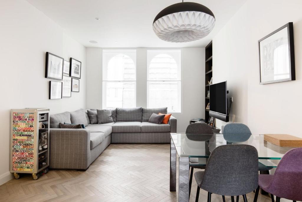 a living room with a couch and a table at Modern Apartment & Rooms at Charing Cross in London