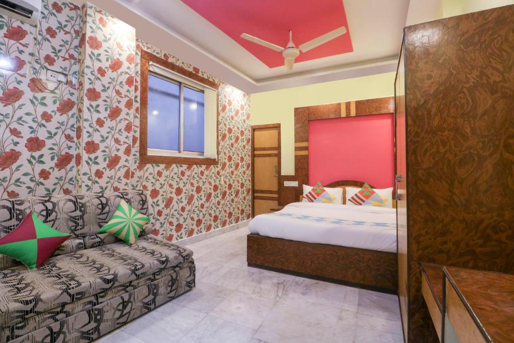 a bedroom with a bed and a couch at OYO Home Cozy Studio Collage Square Hotel Maya International Near St. Thomas's Church in Kolkata