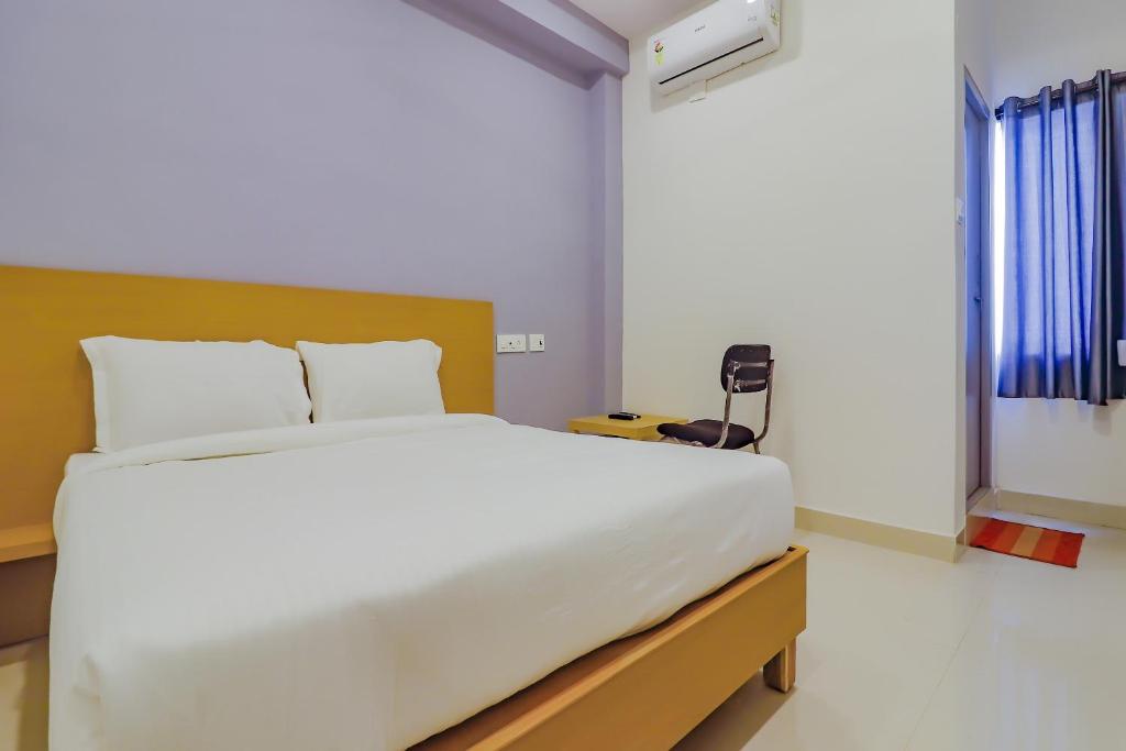 a bedroom with a large white bed with a window at Super OYO Collection O 78286 White Ridge Near LB Nagar in Surūrnagar