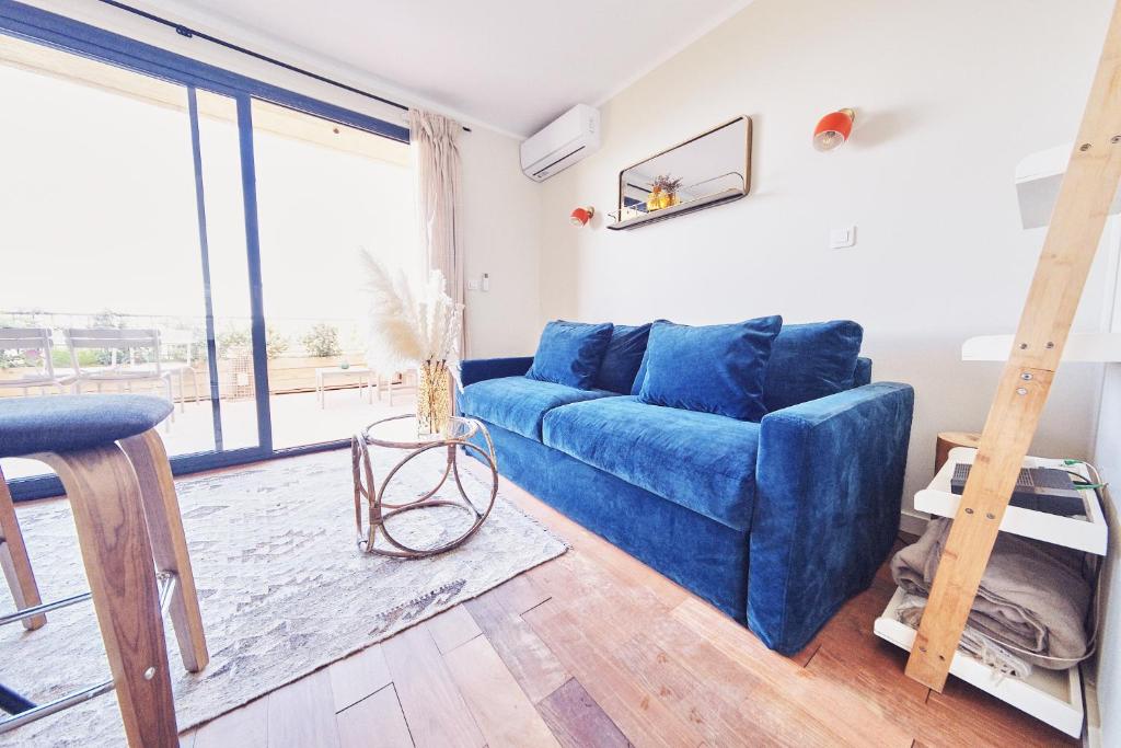 sala de estar con sofá azul y ventana grande en Studio standing - Village Lumio, en Lumio
