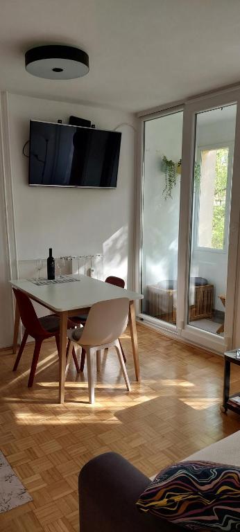 a dining room with a table and chairs and a tv at Zg City suite in Zagreb