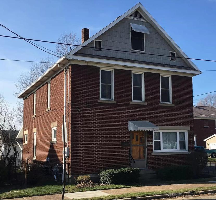 a red brick house with a brown at 2BR Erie Flat Remote Work Family-Friendly in Erie
