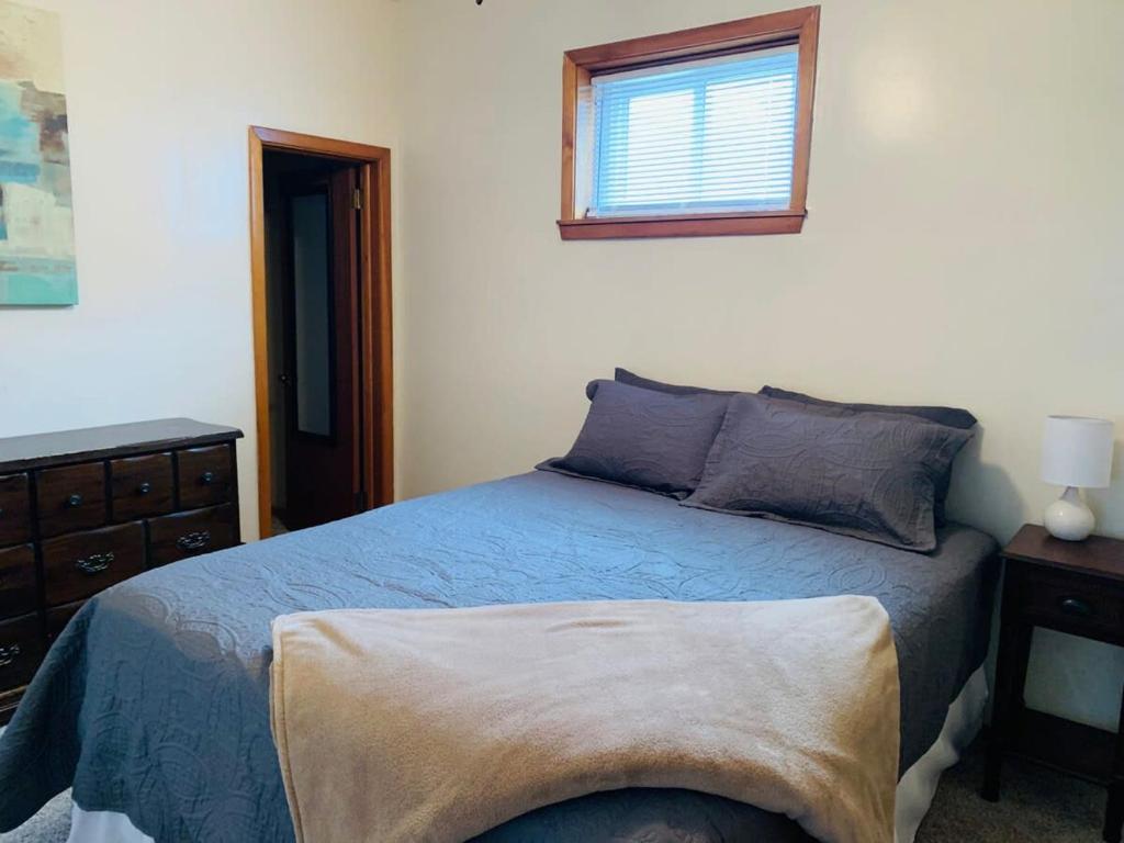 a bedroom with a blue bed and a window at 2BR Erie Flat Near Gannon & Mercyhurst in Erie