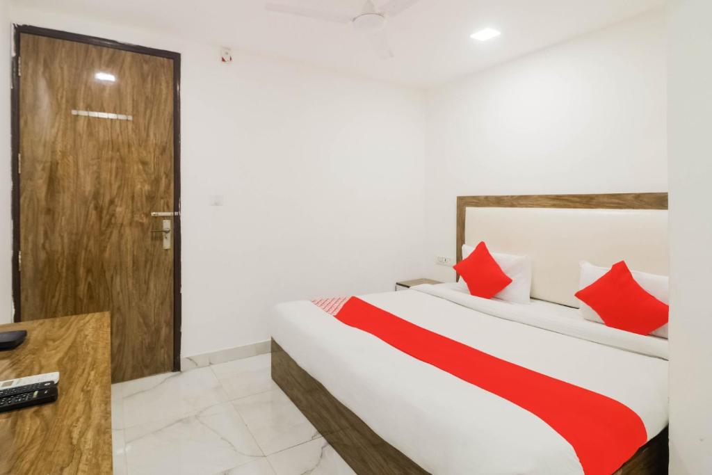 sypialnia z łóżkiem z czerwonymi poduszkami w obiekcie Flagship Gour Plaza w Nowym Delhi