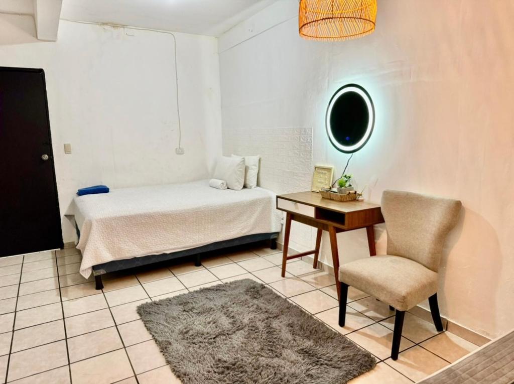 - une chambre avec un lit, un bureau et une chaise dans l'établissement Hotel cielo, à San Salvador
