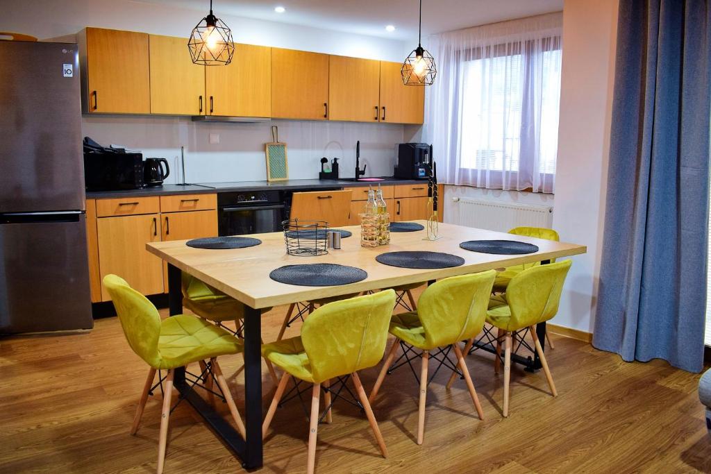 a kitchen with a table and green chairs at Chalupa Martinček in Terchová