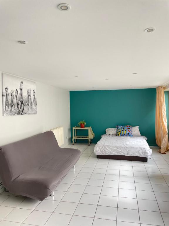 een slaapkamer met een bed en een blauwe muur bij Rooms with garden in Luckyhouse Maison Chatou Paris La Défense in Chatou
