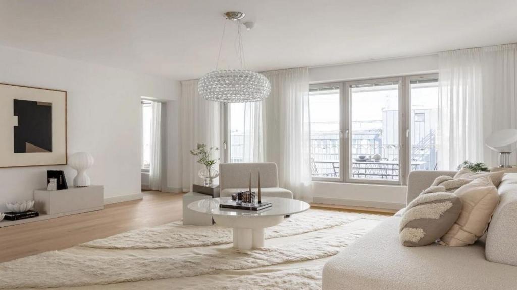 Biały salon z białą kanapą i stołem w obiekcie Modern Apartment for a great stay w Helsinkach