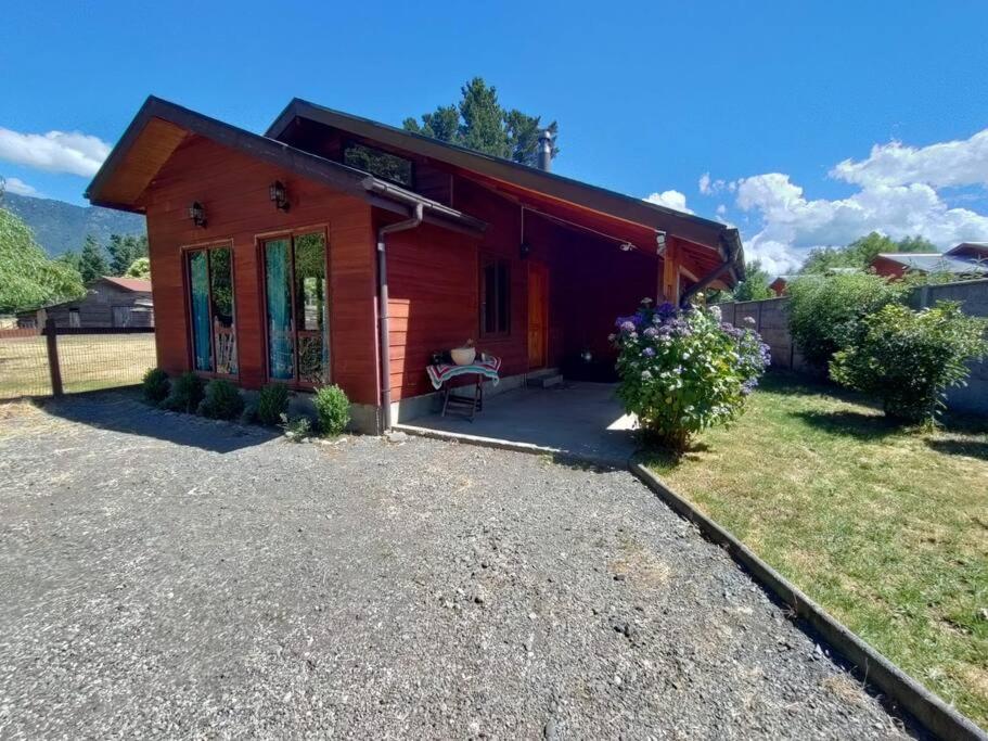 een klein rood huis met een patio ervoor bij Refugio en la ciudad in Pucón