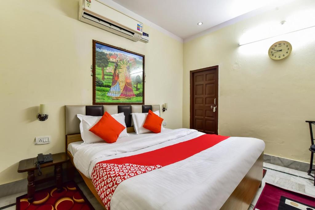 een slaapkamer met een groot bed met oranje kussens bij Super OYO Dev Villas Guest House in Jodhpur