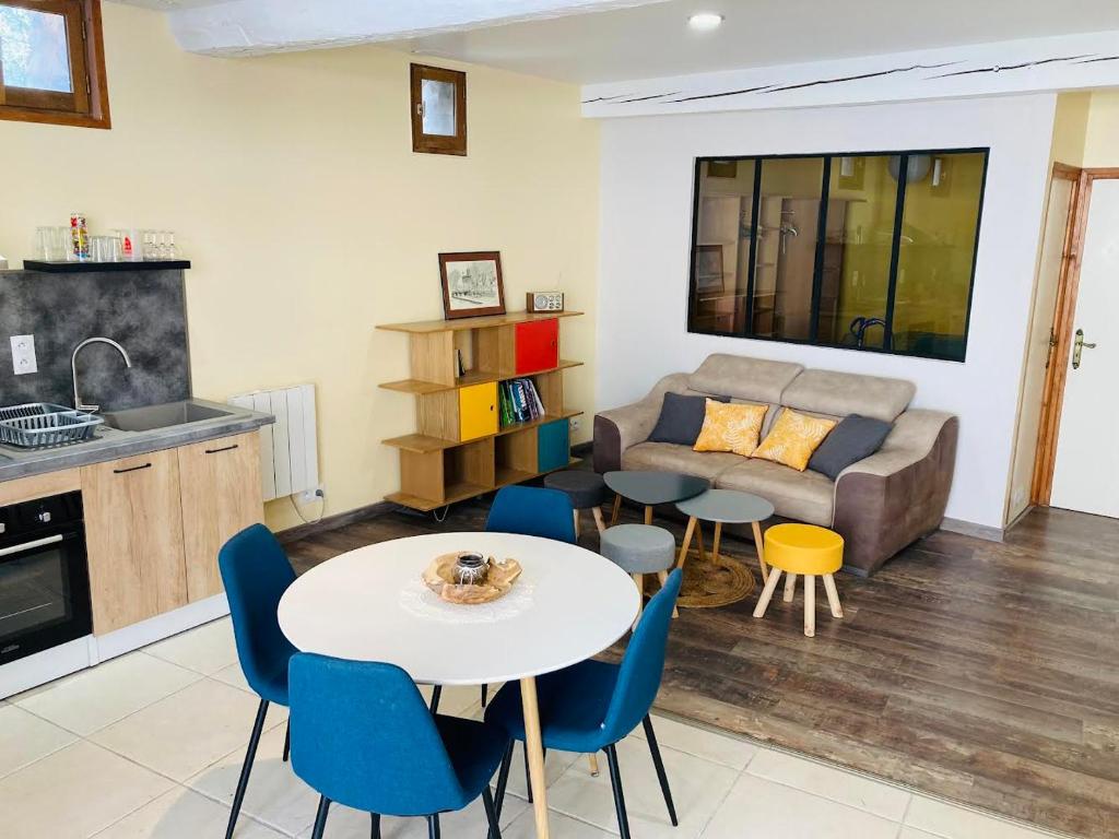 un salon avec une table, des chaises et un canapé dans l'établissement La grange à Papillon, à Saint-Ferriol