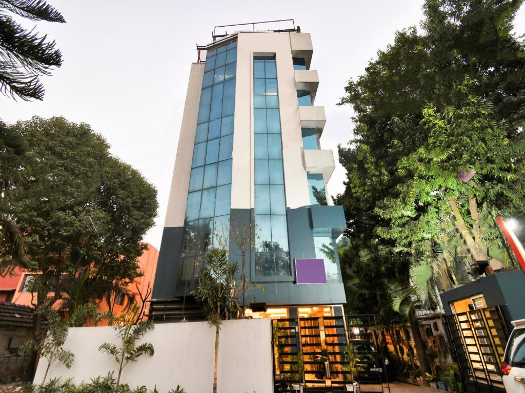 a tall white building with glass windows at Oyo Townhouse Azure Sky in Kolkata