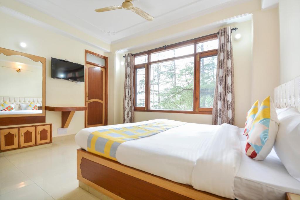 ein Schlafzimmer mit einem großen Bett und einem Fenster in der Unterkunft OYO Home 78009 Avon Villa Kanlog in Shimla