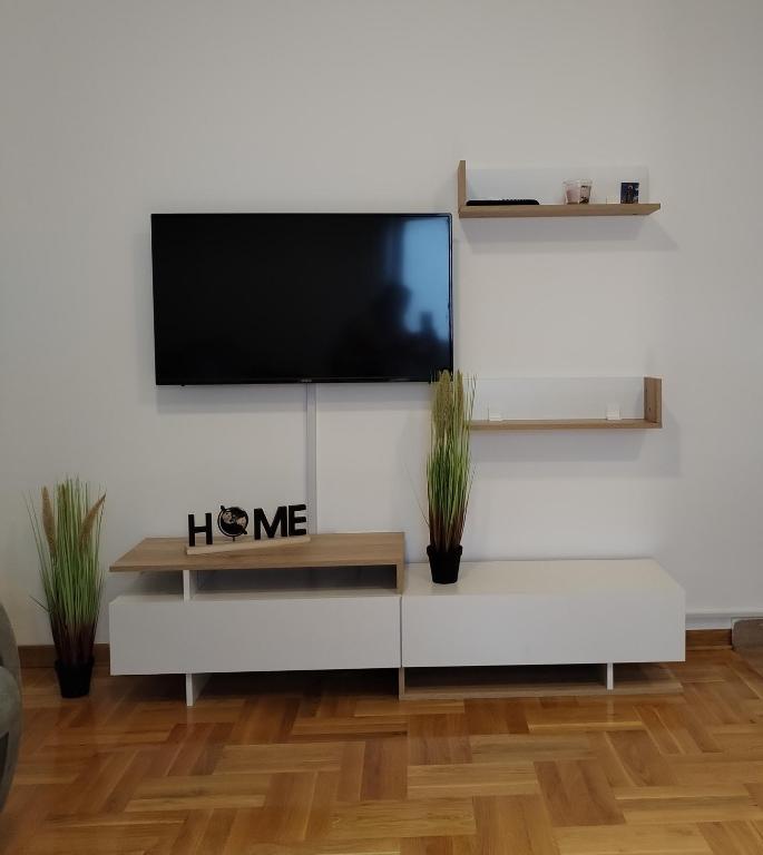een woonkamer met een tv aan een witte muur bij Marko apartman in Surčin