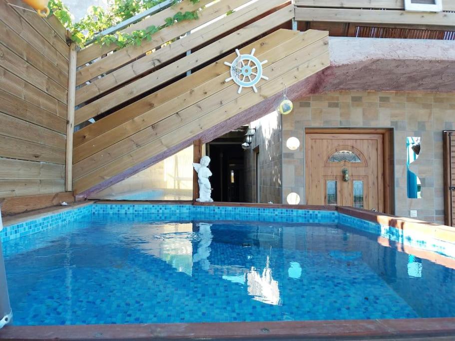a swimming pool in a house with a wooden ceiling at Villa Nigel (5min from Navagio) in Áno Volímai