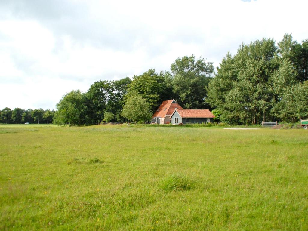 un gran campo con una casa a lo lejos en Beautiful farmhouse in the middle of nature 