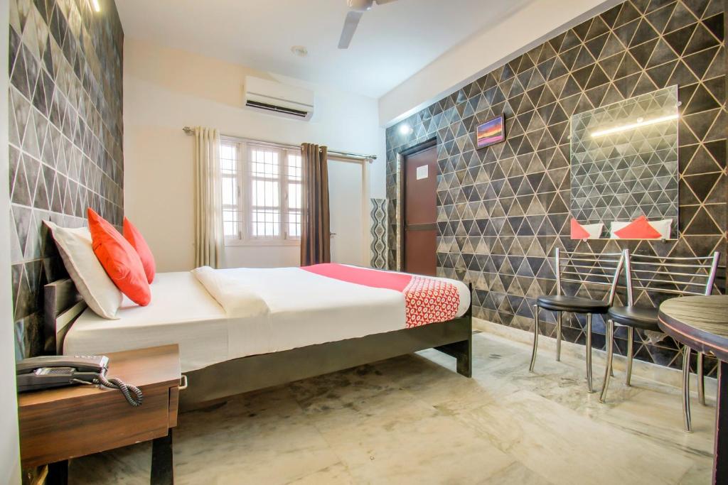 a bedroom with a bed and a table and chairs at OYO Flagship 78696 Hotel Kamini in Patna