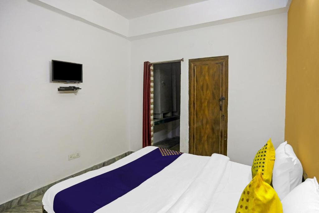 a bedroom with a bed and a tv on the wall at SPOT ON Raj Hotel Vip Near Worlds Of Wonder in Kalkaji Devi