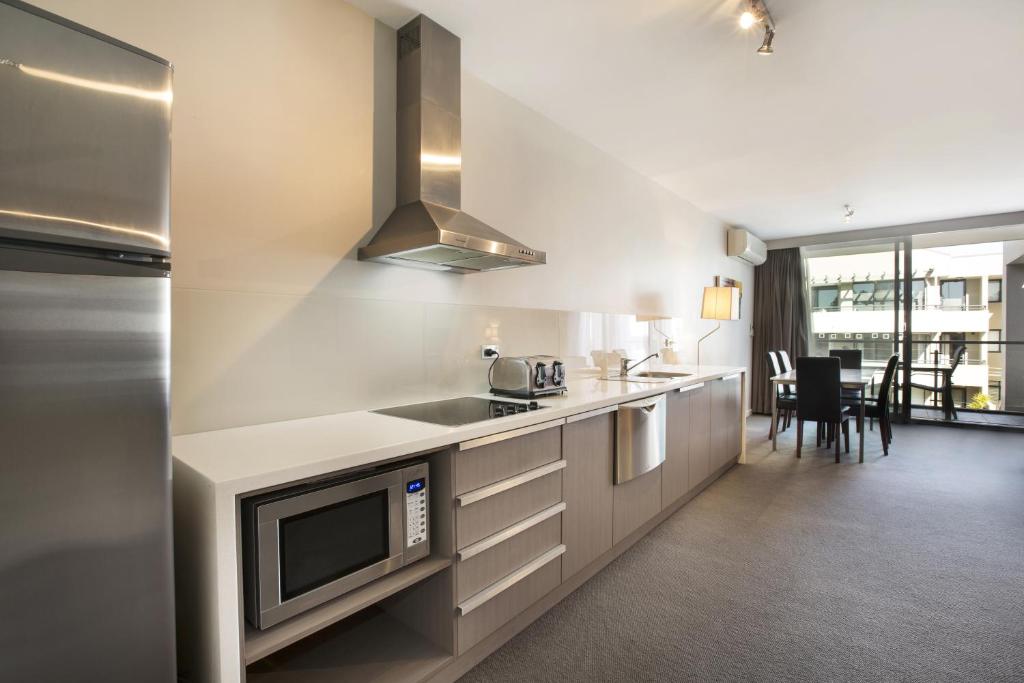 a kitchen with a sink and a microwave at Narrabeen Sands Hotel by Nightcap Plus in Narrabeen