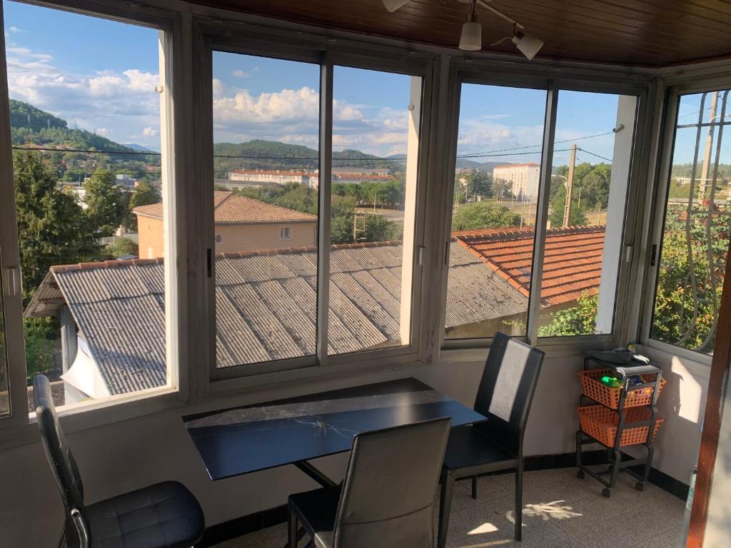 une pièce avec une table, des chaises et des fenêtres dans l'établissement Chambre privée dans Maison d'hotes 10 minutes à pied de la gare et du centre, à Alès