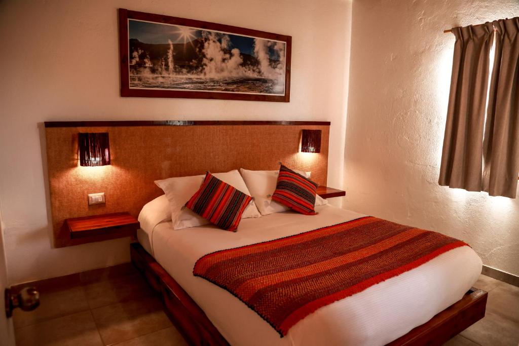 a bedroom with a large bed with two pillows at Tambo Atacama Lodge in San Pedro de Atacama