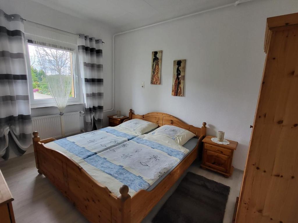 a bedroom with a wooden bed and a window at Ferienwohnung Emira in Wittingen