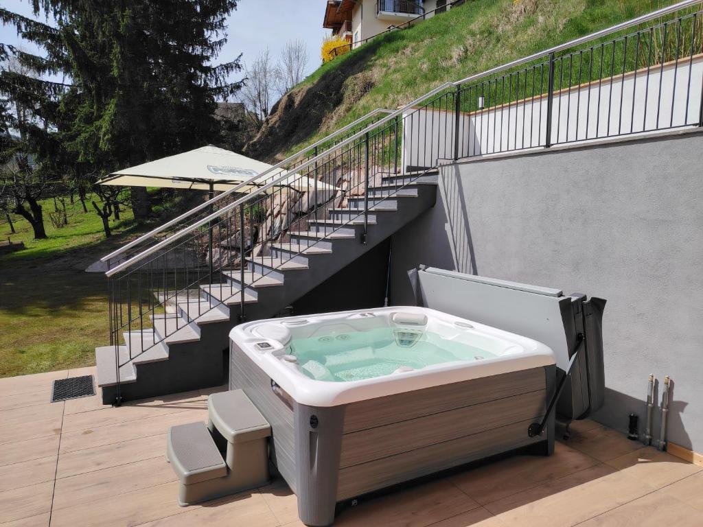 a hot tub sitting on a deck with stairs at MOUNTAIN DELUXE 27 APARTMENTS in Cavalese