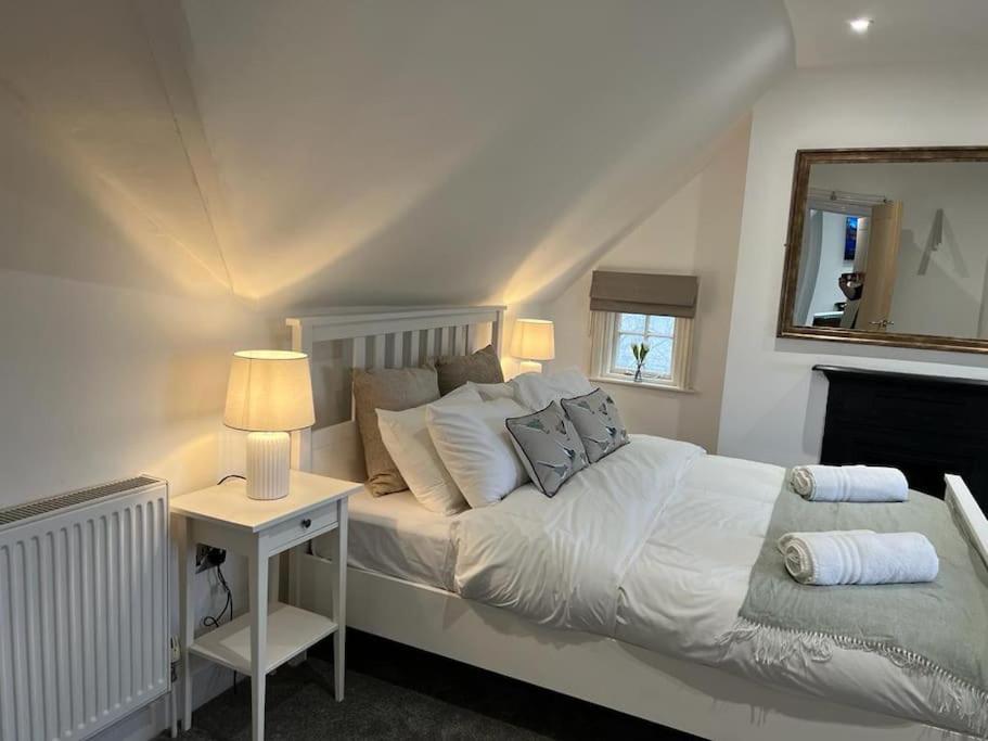 a bedroom with a bed and a table with a mirror at The Loft at Scalford House in Melton Mowbray