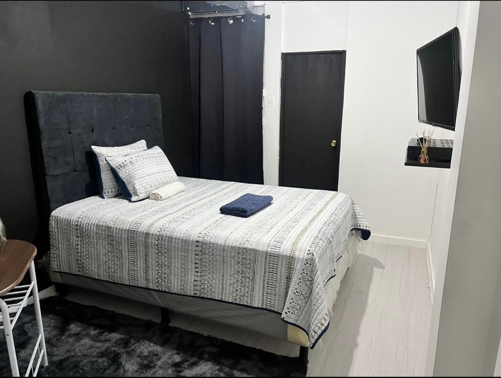 1 dormitorio con 1 cama con edredón blanco en Habitación #2 en San Salvador