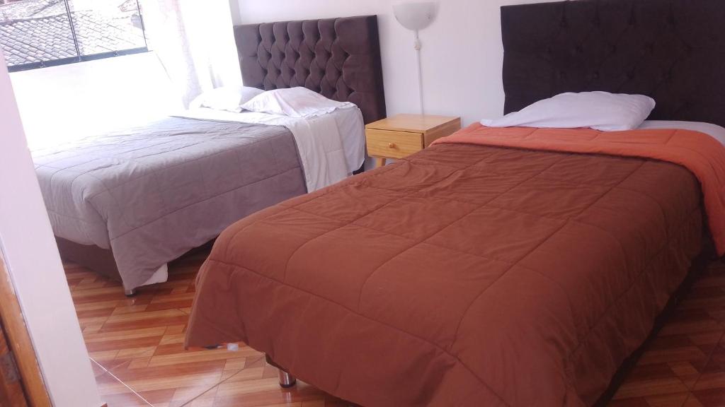 Habitación de hotel con 2 camas y ventana en Hostal festival, en Ollantaytambo