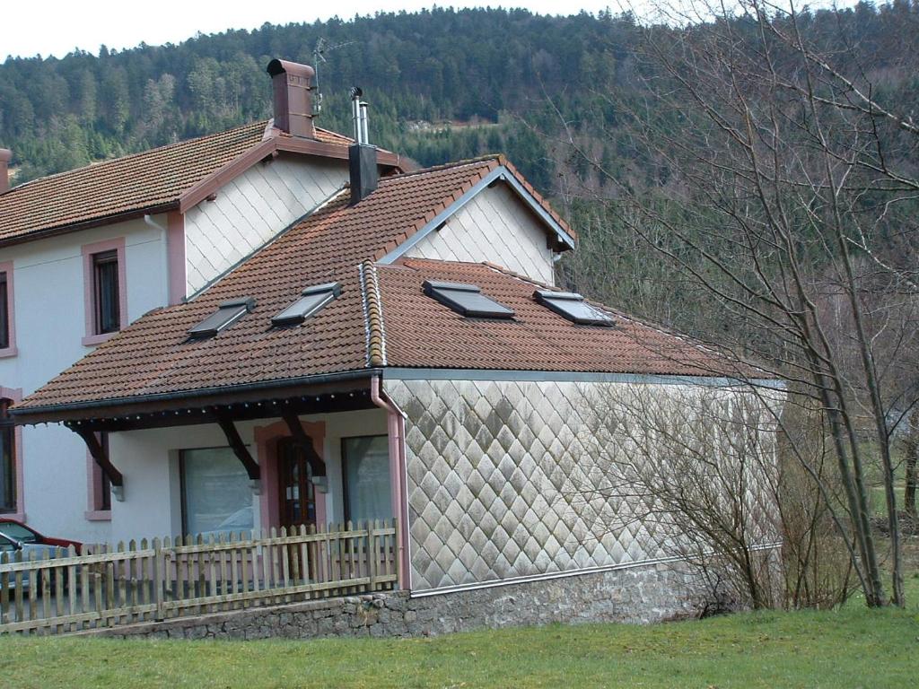 Casa blanca con techo marrón en Appt 4 pers-chalet l'ancienne école en La Bresse