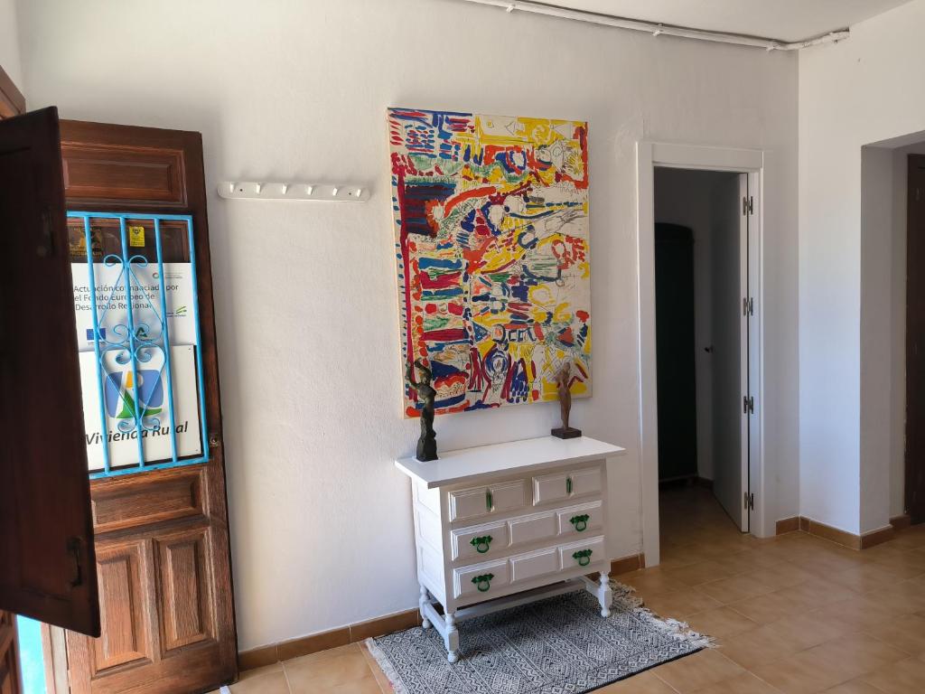 エル・ポソ・デ・ロス・フライレスにあるVivienda rural en Cabo de Gataの壁画とドレッサー付きの部屋