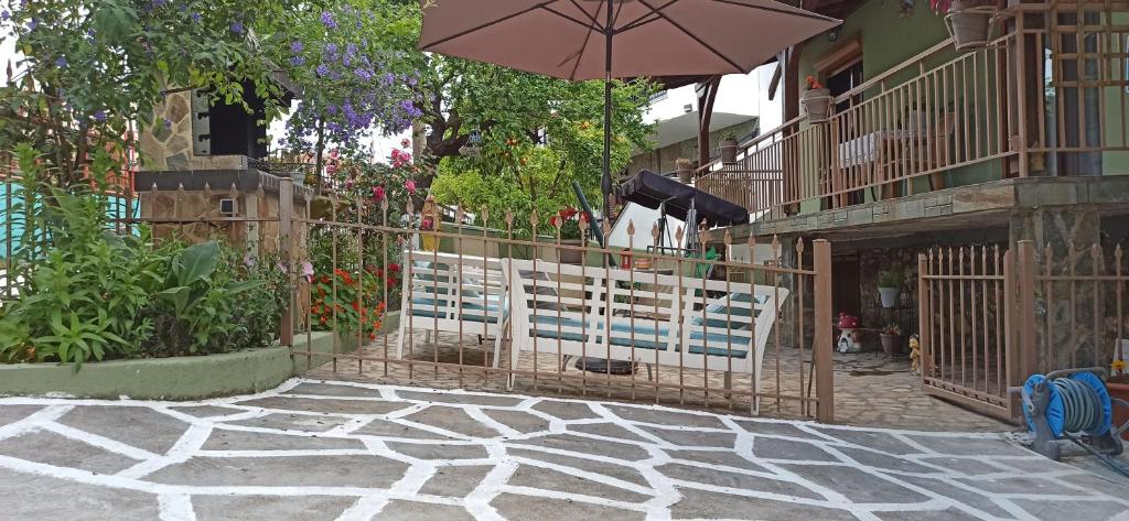 a couple of chairs and an umbrella on a patio at Blue Fairytale in Agios Nikolaos