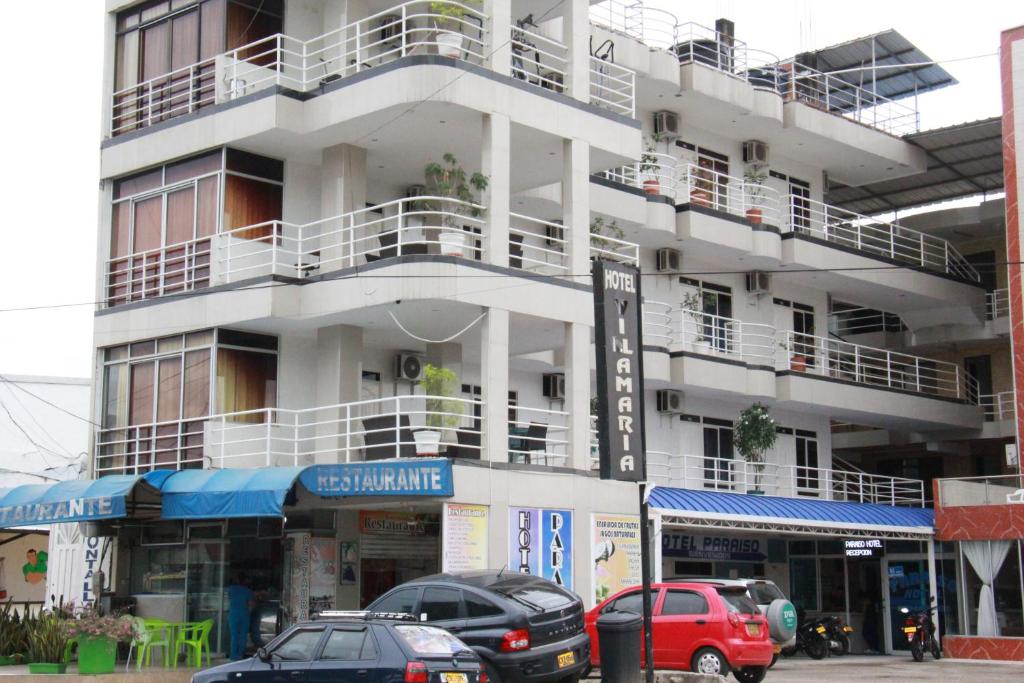約帕爾的住宿－HOTEL PARAISO DE LA 30，一座白色的建筑,前面有汽车停放