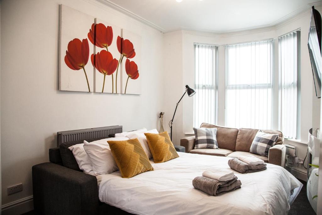 a bedroom with a bed with red flowers on the wall at MantonHouse by Sheryl - Sleeps 7 in Liverpool