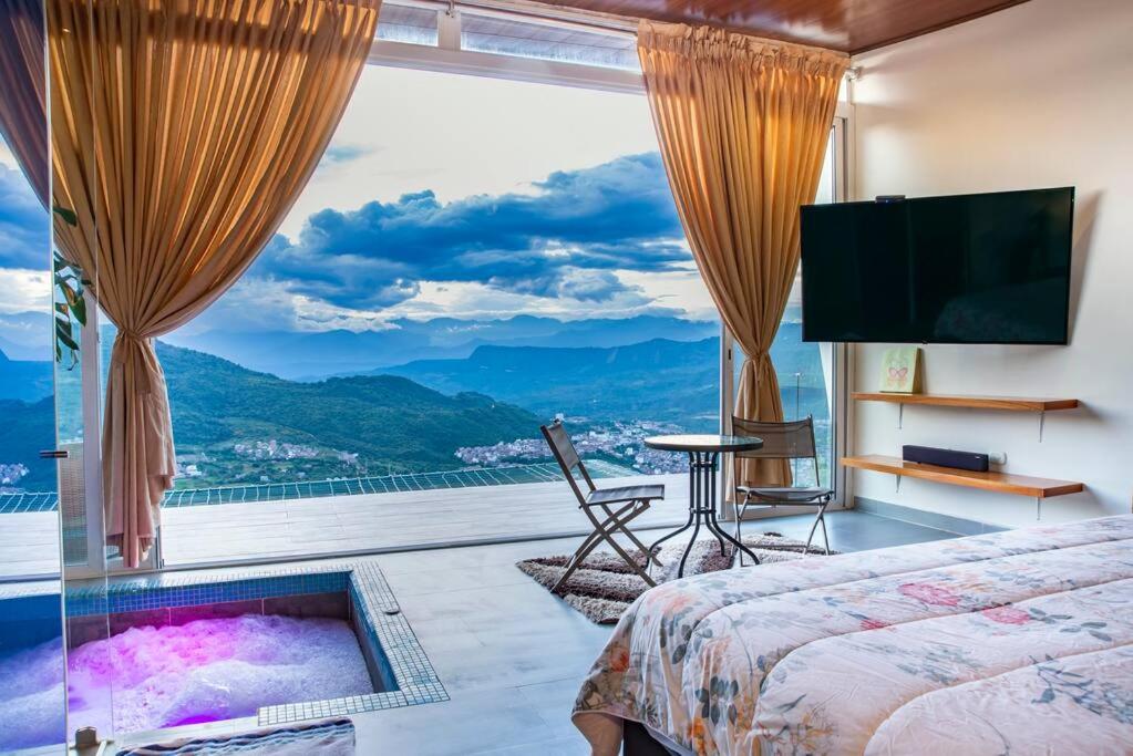 een slaapkamer met een groot raam met een tv en een bed bij Glamping Luxury vista infinita y Jaccuzi en Sangil in San Gil