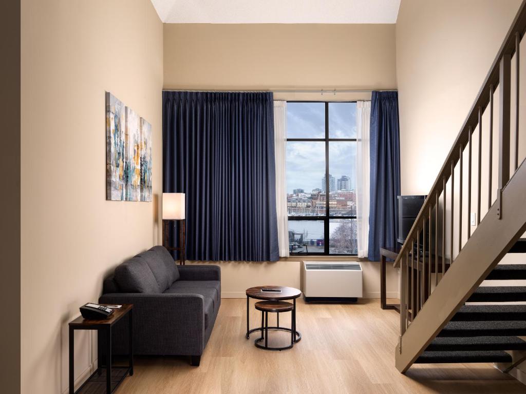 a living room with a couch and a window at Huntingdon Hotel and Suites in Victoria