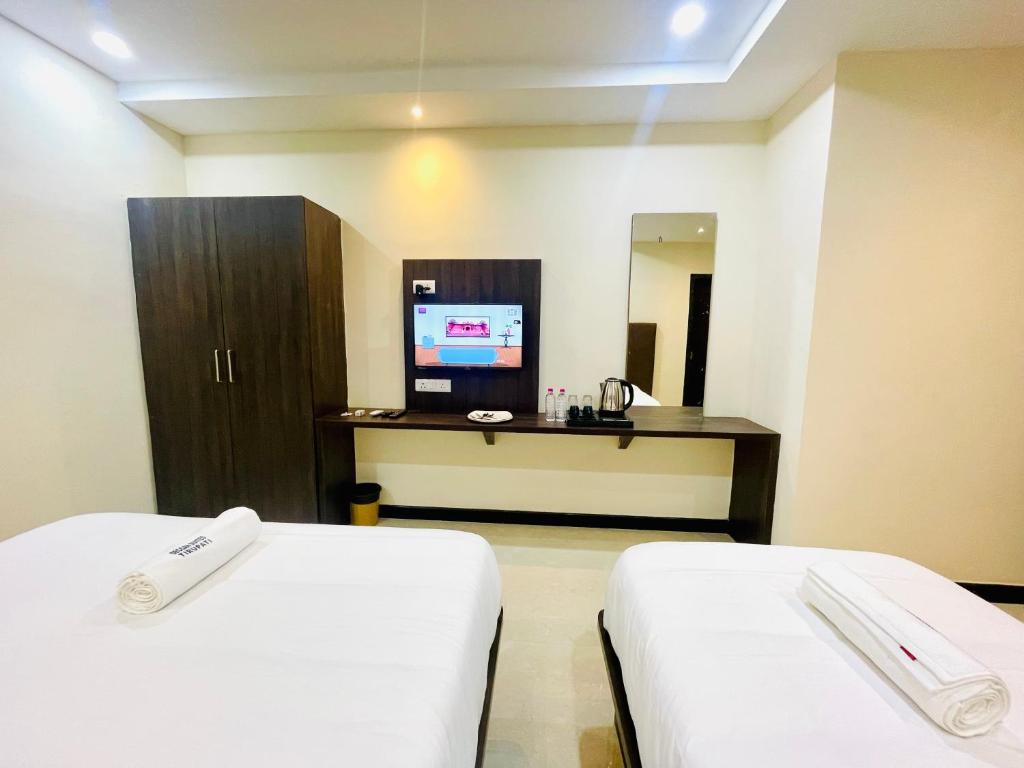 Postel nebo postele na pokoji v ubytování Deccan Suites, Tirupati
