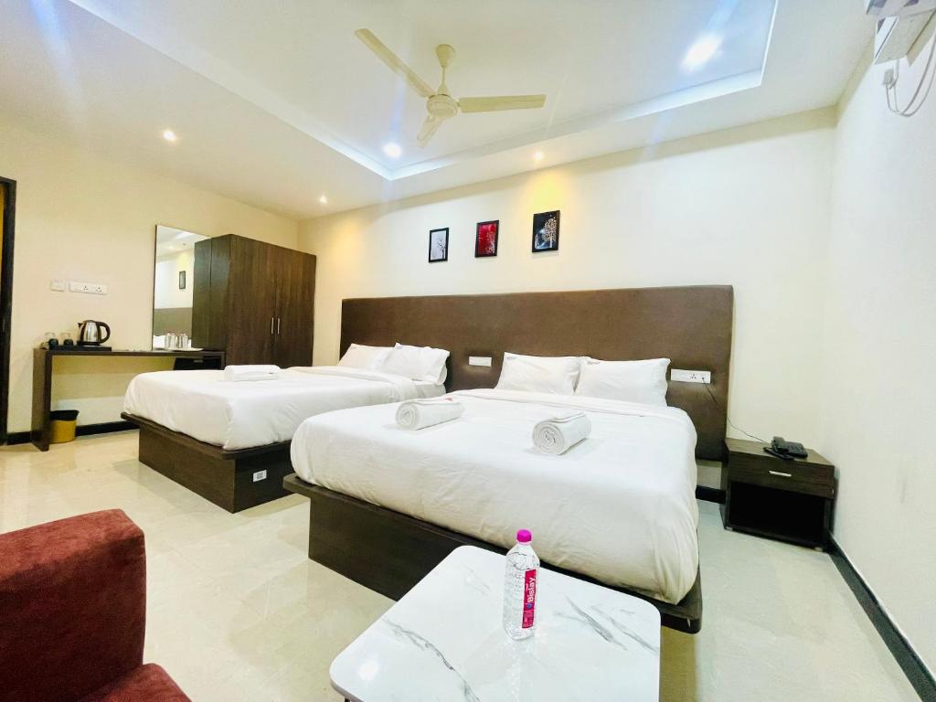 Postel nebo postele na pokoji v ubytování Deccan Suites, Tirupati