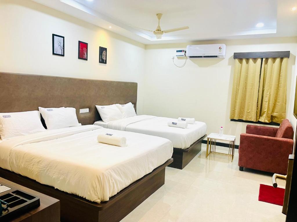 Postel nebo postele na pokoji v ubytování Deccan Suites, Tirupati